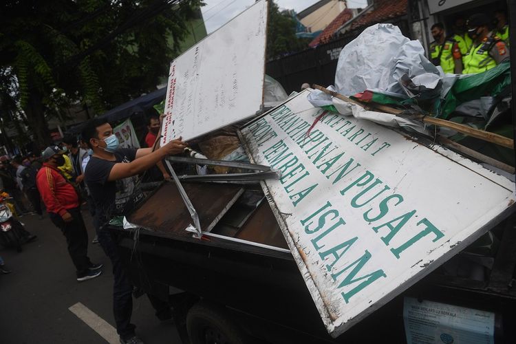 Petugas membongkar atribut-atribut saat melakukan penutupan markas  DPP Front Pembela Islam (FPI) di Petamburan, Jakarta, Rabu (30/12/2020). Polisi dan TNI menutup markas FPI setelah pemerintah memutuskan untuk membubarkan organisasi pimpinan Rizieq Shihab itu. ANTARA FOTO/Akbar Nugroho Gumay/nz