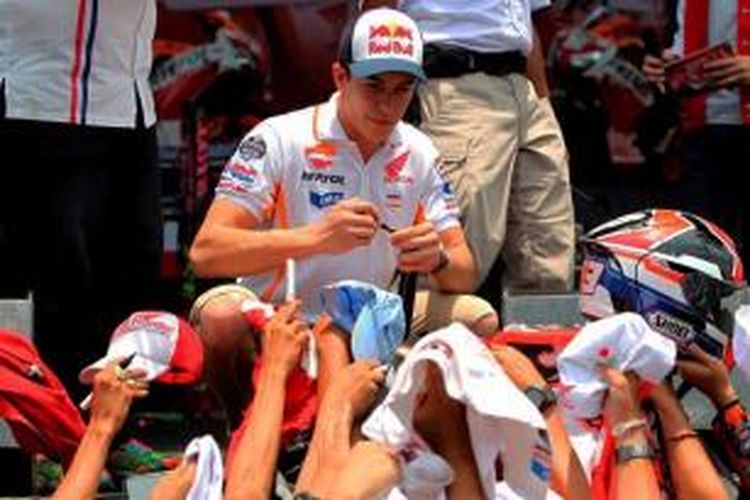 Pebalap Repsol Honda asal Spanyol, Marc Marquez, memberikan tanda tangan kepada para penggmar yang hadir di Sirkuit Sentul, Bogor, jawa Barat, Selasa (21/10/2014).