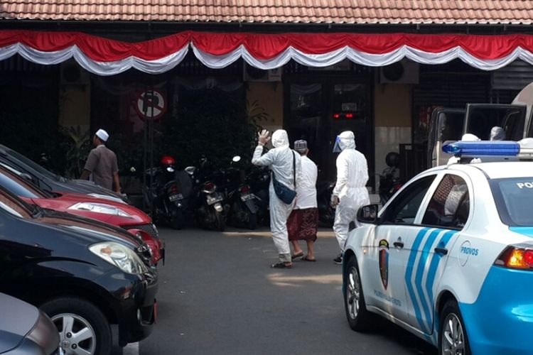 Warga yang merebut jenazah saat keluar dari ambulance dokter polisi didampingi petugas yang mengenakan APD lengkap di Mapolresta Malang Kota, Selasa (18/8/2020).