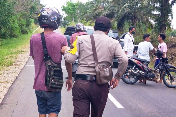 Petugas mengamankan pemuda yang melakukan ngabuburit sambil balap liar di Jalan Pasir Baru, Kecamatan Rambah, Kabupaten Rohul, Riau, Senin (27/4/2020).