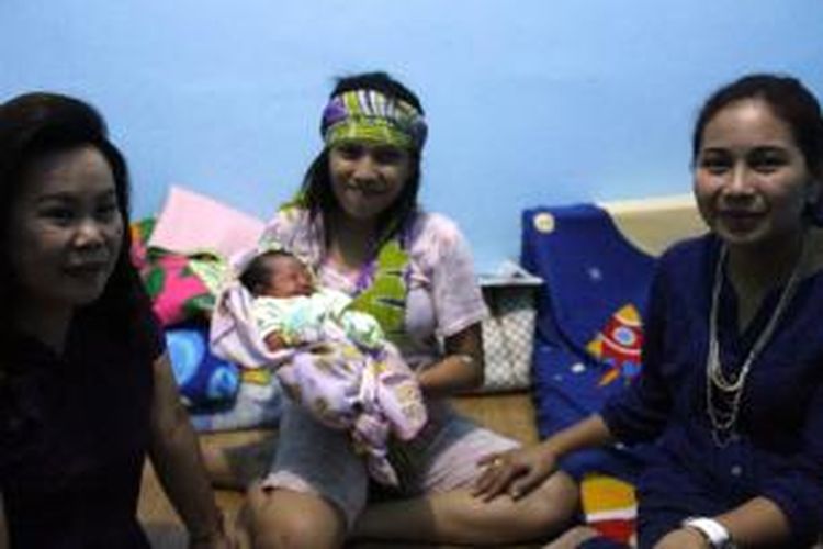 Desi (berikat kepala), tahanan Rutan Malendeng Manado sedang memeluk anaknya yang lahir didalam mobil, didamping Istri Wakil Walikota Manado, Seyla Sychilia Mangindaan-Kudati (kanan).