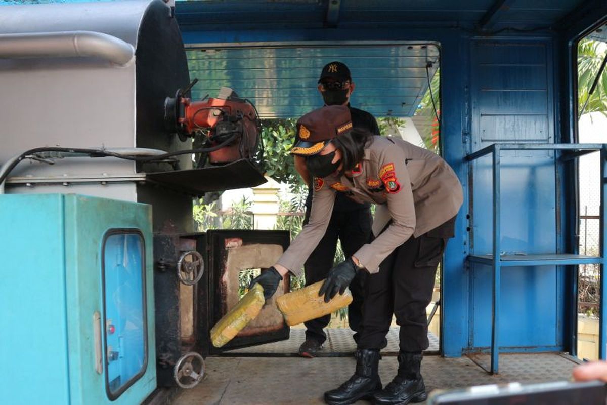 Wakapolres Pelabuhan Tanjung Priok Kompol Yunita Natallia Rungkat memasukkan ganja kering ke dalam tungku dalam kegiatan pemusnahan narkotika yang berlangsung di halaman Mapolres Pelabuhan Tanjung Priok di Jakarta, Rabu (24/8/2022). 