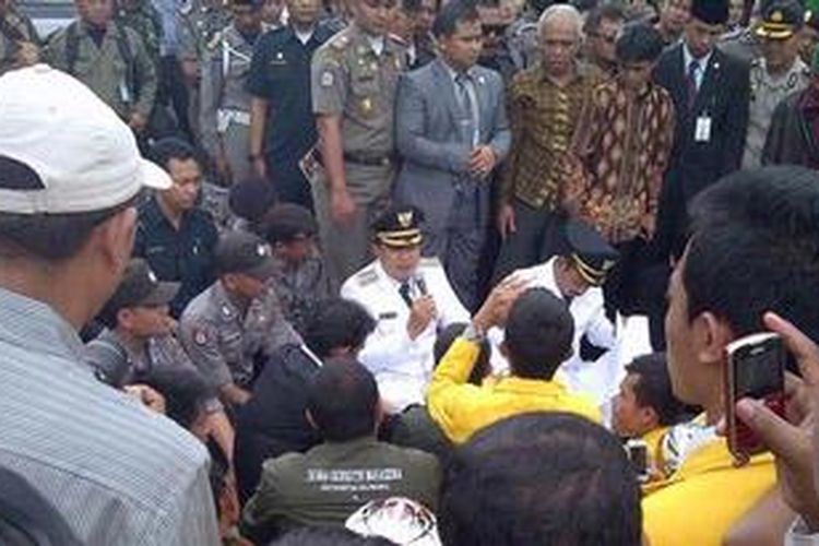 Pasangan Wali Kota dan Wakil Wali Kota Tasikmalaya, Budi Budiman dan Dede Sudrajat, duduk di tengah jalan saat menemui pendemo, Rabu (14/11/2012) siang. 