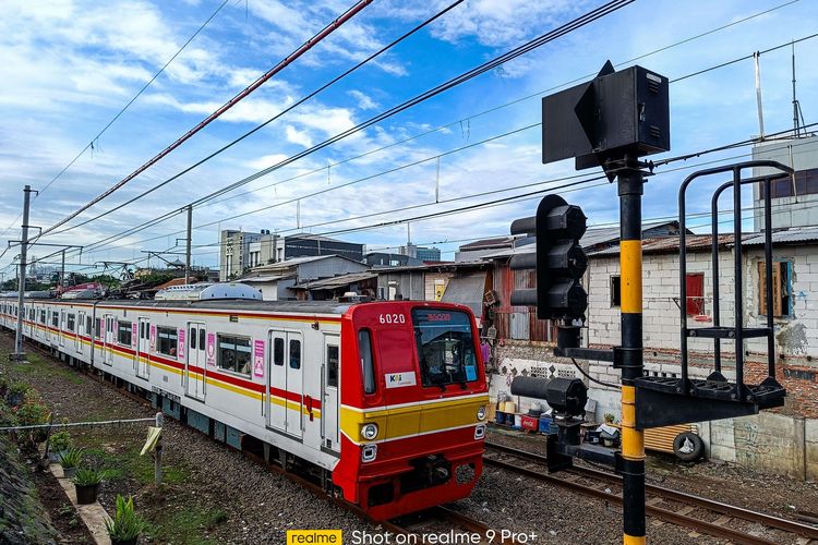 Kereta Rangkaian Listrik (KRL) melintas di kawasan Banjir Kanal Barat, Jakarta, Senin, (14/2/2022). Pengambilan gambar diambil dengan smartphone Realme 9 Pro+ Mode Photo