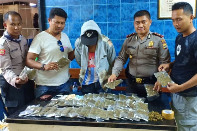 Pelaku dan barang bukti ganja kering yang dikemas dalam plastik bening.