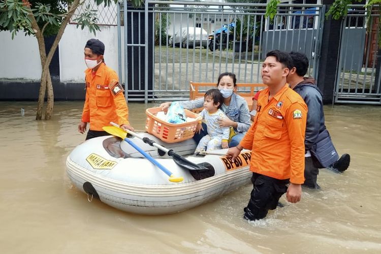 Petugas BPBD Kota Serang membantu masyarakat yang terdampak banjir di Perumahan Untirta