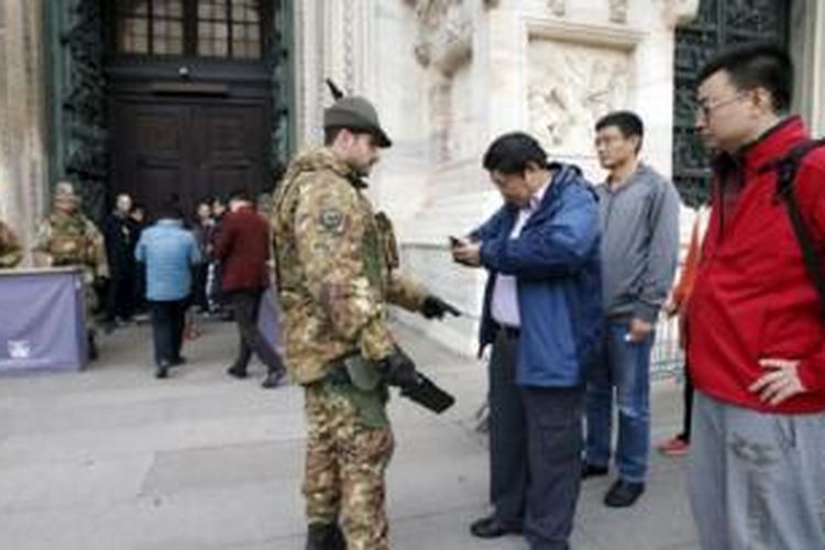 Tentara Italia memeriksa pengunjung di luar gereja Katedral Milan, utara Italia (20/11). Italia dan Swedia meningkatkan pengamanan di wilayah mereka menyusul serangan di Paris minggu lalu.
