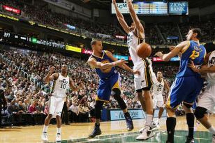 Pebasket Golden State Warriors, Stephen Curry (kiri, biru), memberikan umpan pada rekan satu timnya, Andrew Bogut (kanan, biru) pada pertandingan melawan Utah Jazz di EnergySolutions Arena, Jumat (31/01/2014).