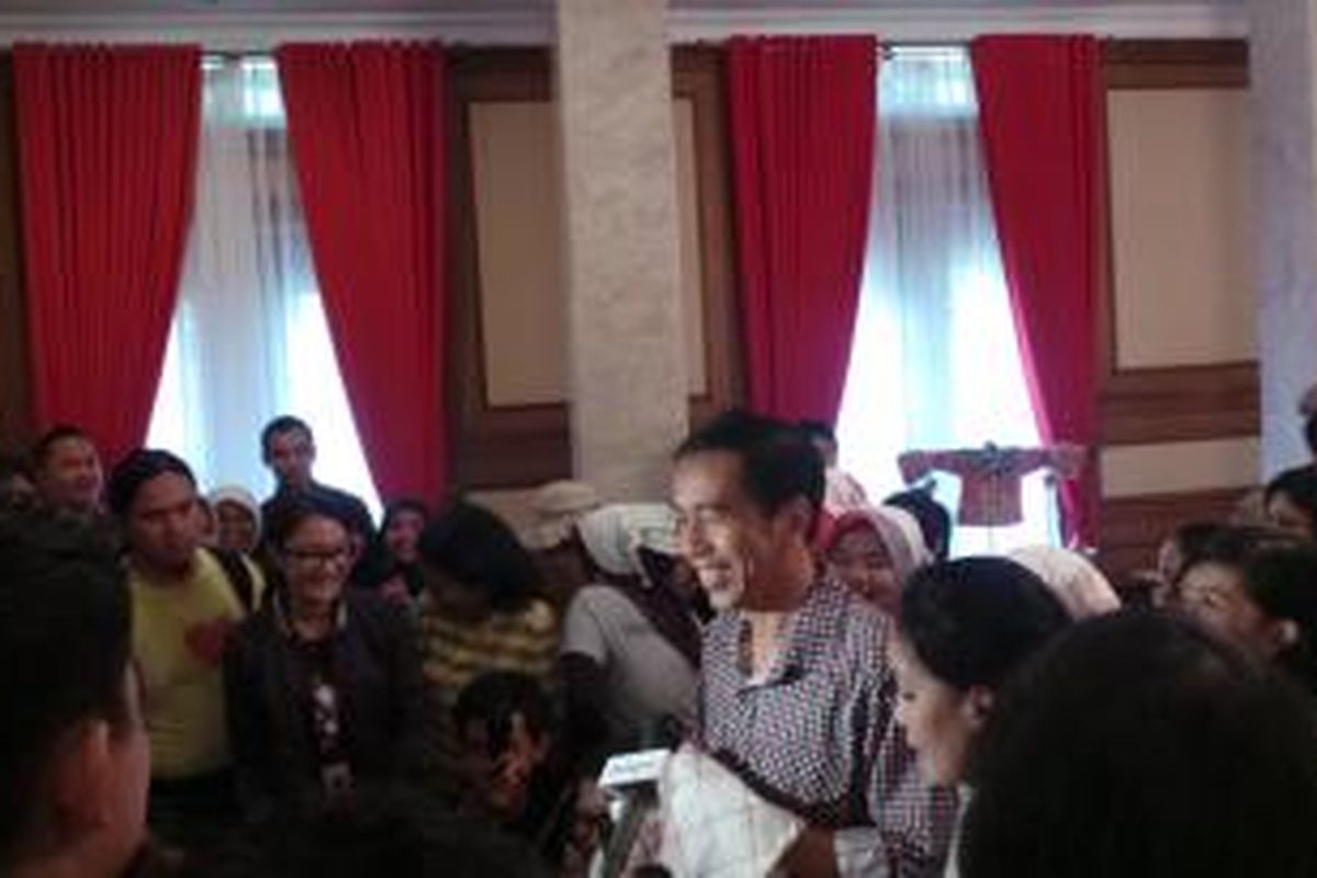 Gubernur DKI Jakarta Joko Widodo menerima serbet putih dari para pembantu rumah tangga yang mendatangi rumah dinasnya, Kamis (1/5/2014).