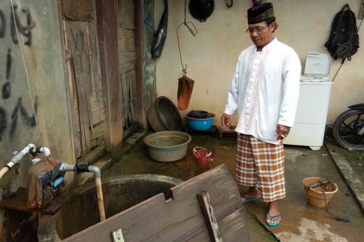 Sutikno, warga Dusun Wamsait, Desa Dava, Kecamatan Wailata, Kabupaten Buru berdiri di dekat sumur rumahnya yang kini tidak bisa lagi dimanfaatkan sebagai sumber air minum, Jumat (16/3/2018).