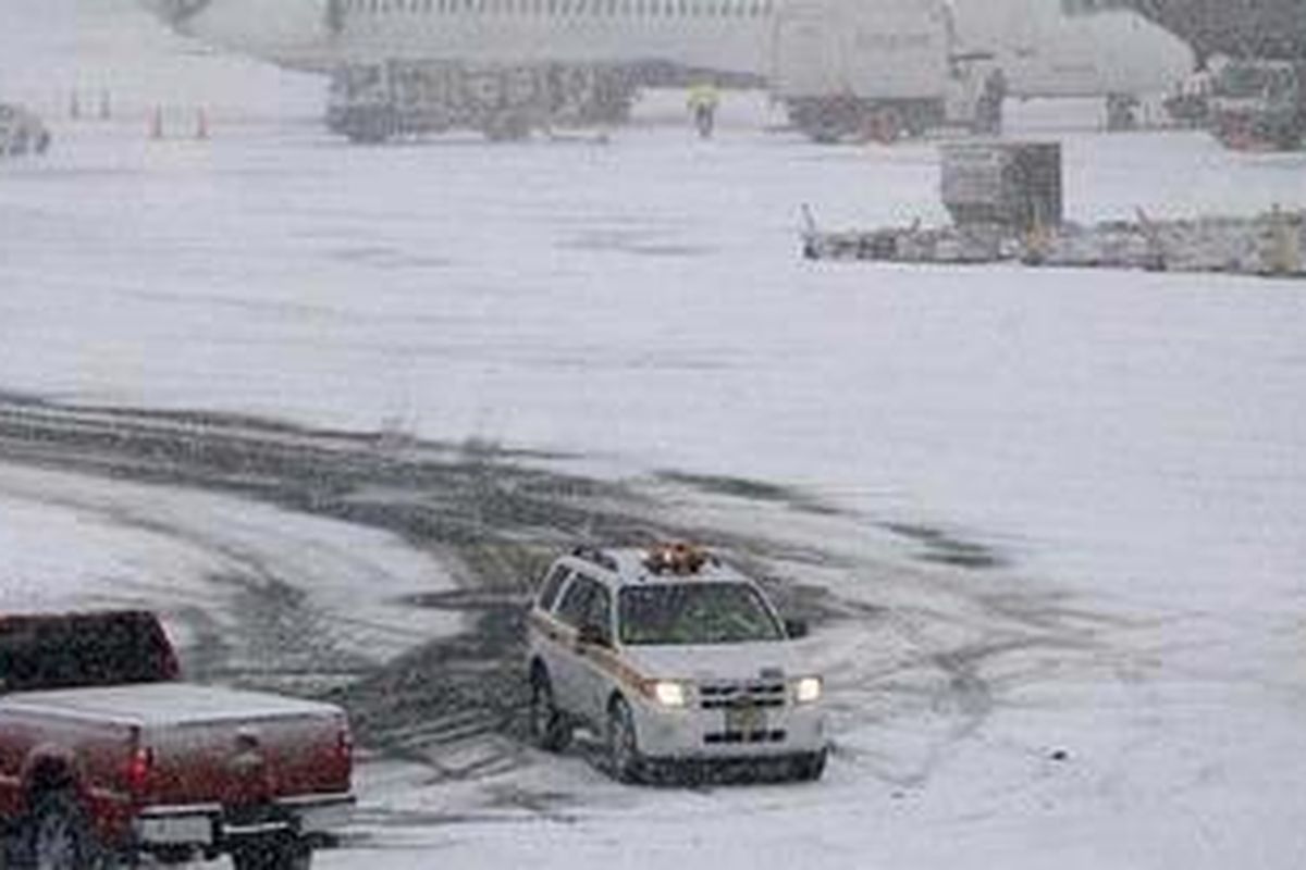 Sebuah pesawat Delta terlihat di Bandar Udara Internasional Newark Liberty saat badai salju, Minggu (26/12/2010, di Newark.