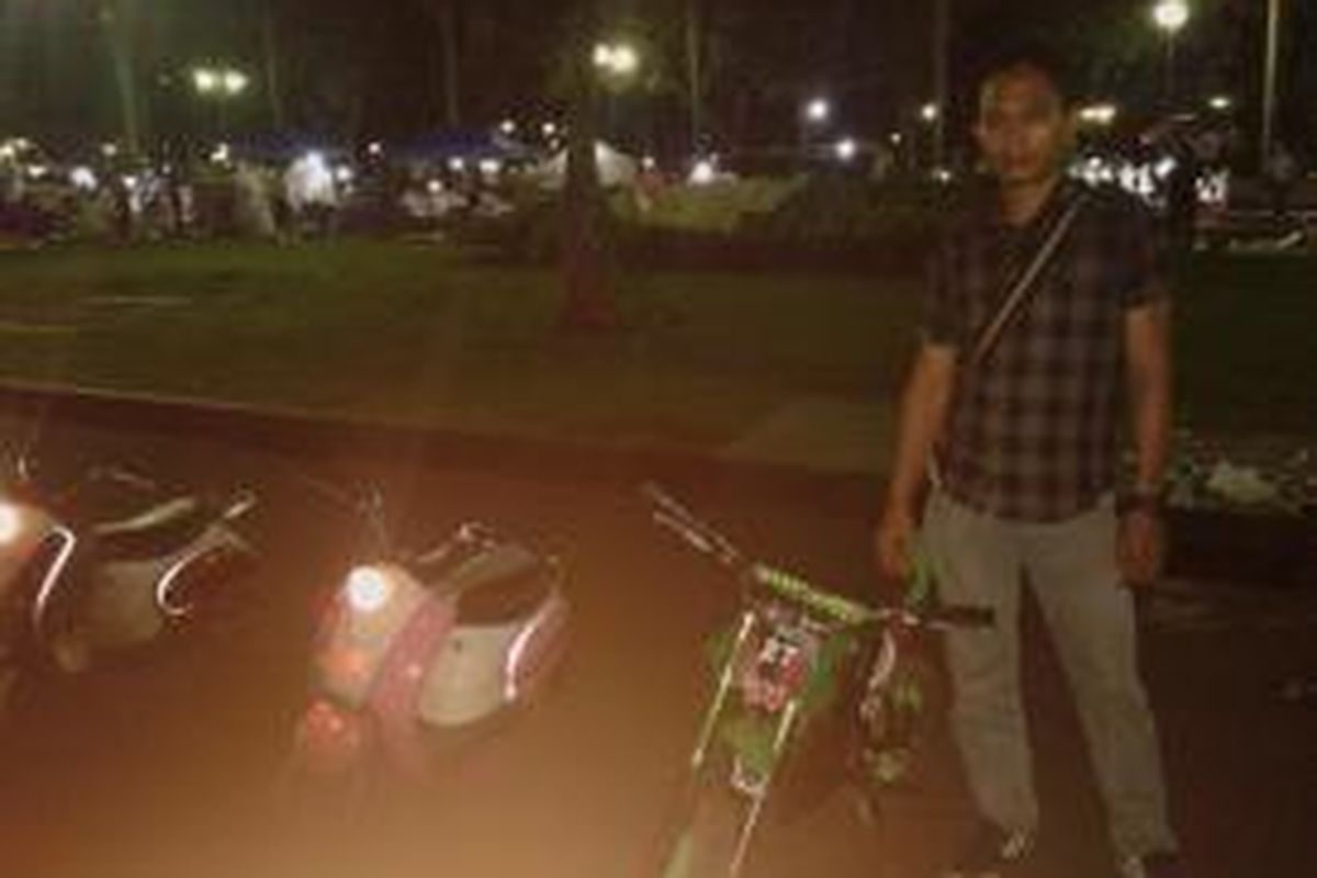 Penyewa jasa motor mini di kawasan Monas, Jakarta Pusat, di malam Takbiran. Minggu (27/7/2014).