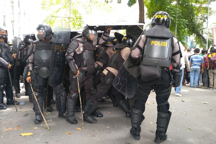 Polisi bersiaga saat terjadi aksi lempar batu dalam unjuk rasa di DPRD Sumut pada Kamis (8/10/2020) yang sempat berlangsung rusuh.