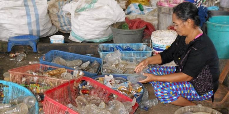Buruh Di Tempat Daur Ulang Sampah Plastik, Hanasiah (46), sedang memilah-milah sampah plastik. Walau kerjanya sebagai buruh sampah, ia masih bisa membantu perekonomian keluarganya