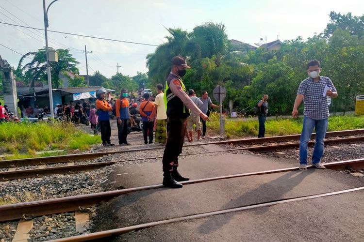 Petugas kepolisian menunjukkan, lokasi dua pelajar tewas usai tertabrak kereta api di perlintasan tanpa palang pintu di Desa Surabayan, Kecamatan Sukodadi, Lamongan, Senin (24/1/2022).