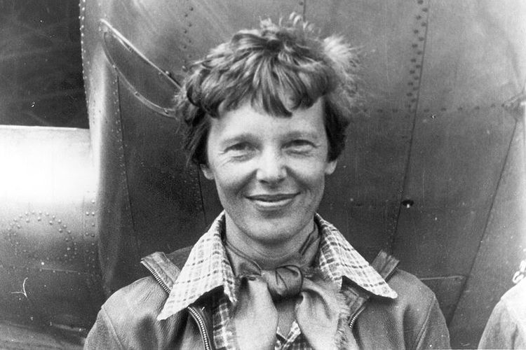 Amelia Earhart berfoto di bawah pesawat Lockheed model 10E-Electra yang diterbangkannya dalam upaya keliling dunia yang berakhir setelah dia dinyatakan hilang di Samudera Pasifik.