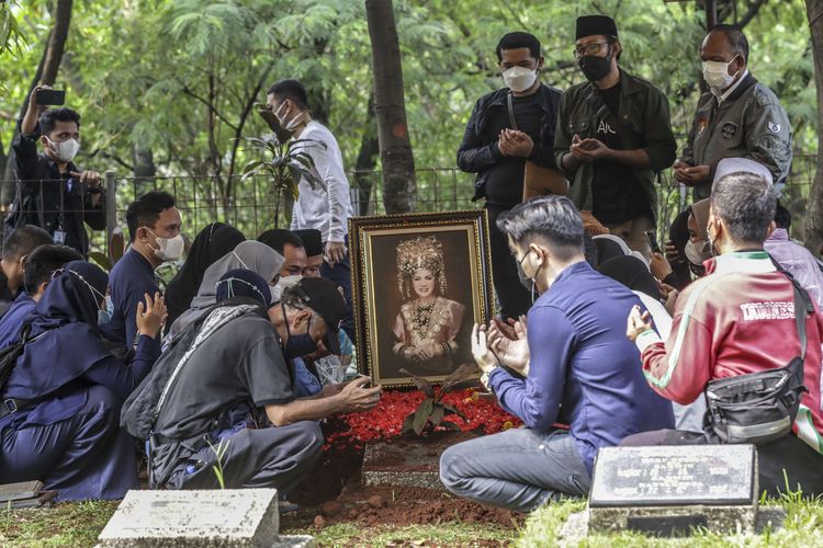 Kerabat berdoa di atas pusara artis senior Dorce Gamalama usai dimakamkan di TPU Bantar Jati, Cipayung, Jakarta, Rabu (16/2/2022). Dorce Gamalama meninggal dunia pada usia 59 tahun akibat infeksi virus COVID-19.