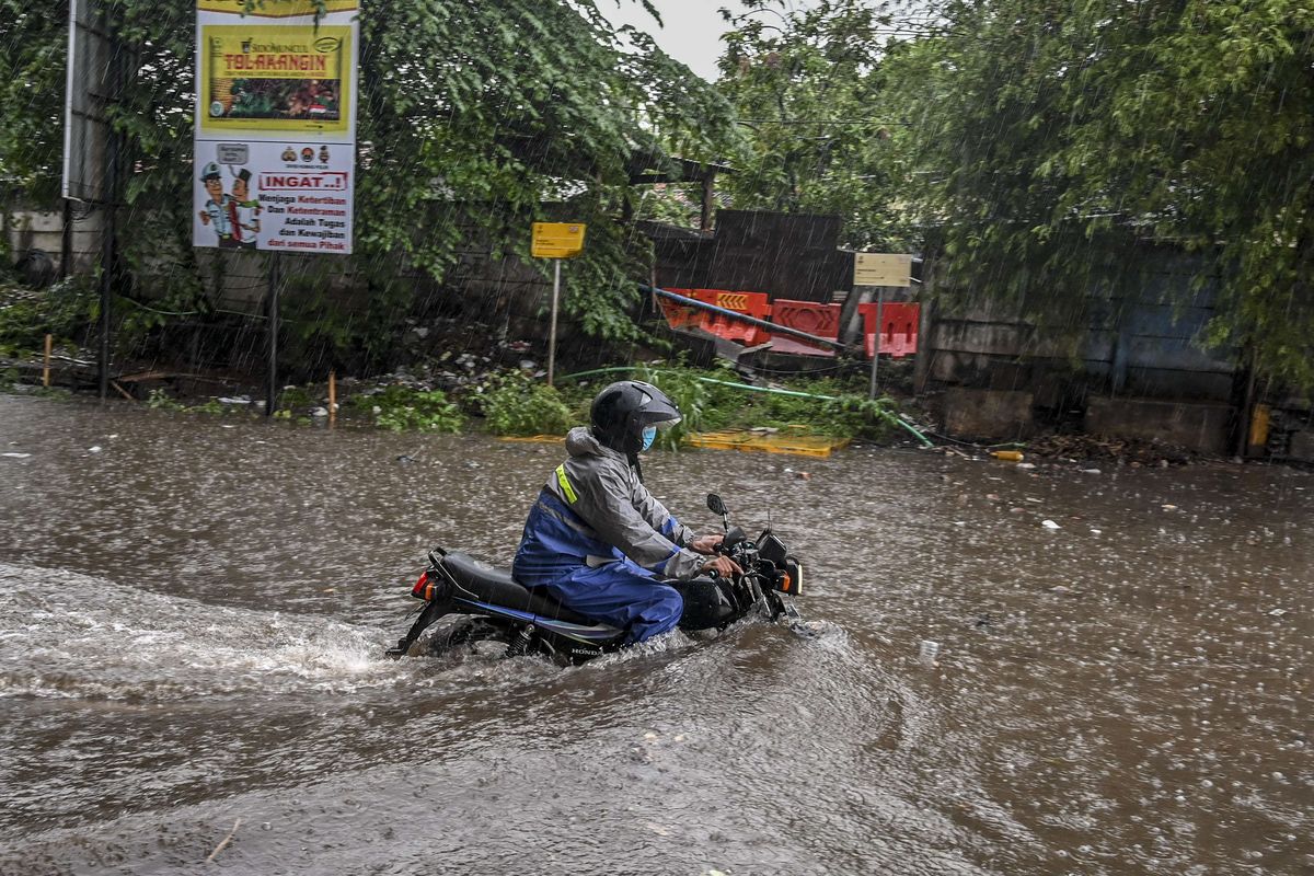 Pengendara sepeda motor melintas saat banjir di kawasan Jalan Akses Tol Cibitung, Bekasi, Jawa Barat, Sabtu (30/4/2022). Banjir di kawasan tersebut disebabkan banyaknya sampah yang menyumbat saluran air (drainase).