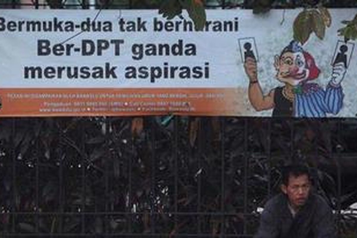 Warga beristirahat di bawah spanduk tentang Daftar Pemilih Tetap (DPT) yang terpasang di pinggir Jalan Suryopranoto, Jakarta Pusat, Sabtu (19/5/2012). Banyak pihak berharap agar tidak terdapat pemilih fiktif dalam DPT sehingga Pilgub DKI Jakarta dapat berjalan dengan jujur dan bersih. 