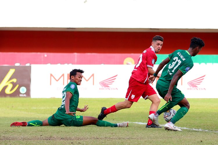 Pemain asing Persis Solo  Alexis Messidoro dijaga ketat pemain Persebaya Surabaya saat pertandingan pekan ke-16 Liga 1 2022-2023 yang berakhir dengan skor 0-0 di Stadion Maguwoharjo Sleman, Rabu (21/12/2022) sore.