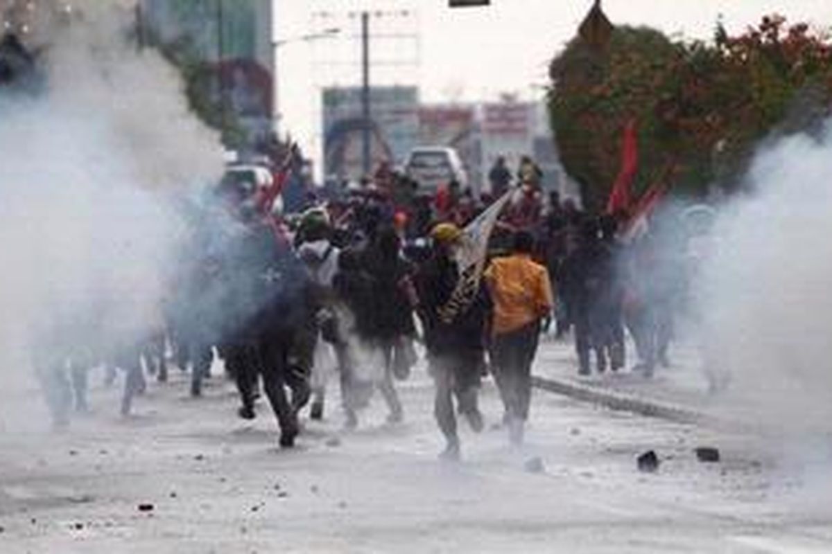 Mahasiswa yang menolak rencana kenaikan bahan bakar minyak (BBM) menghindari gas air mata saat berunjuk rasa di depan Kantor DPR, Jalan Gatot Subroto, Senayan, Jakarta, Kamis (29/3/2012). 