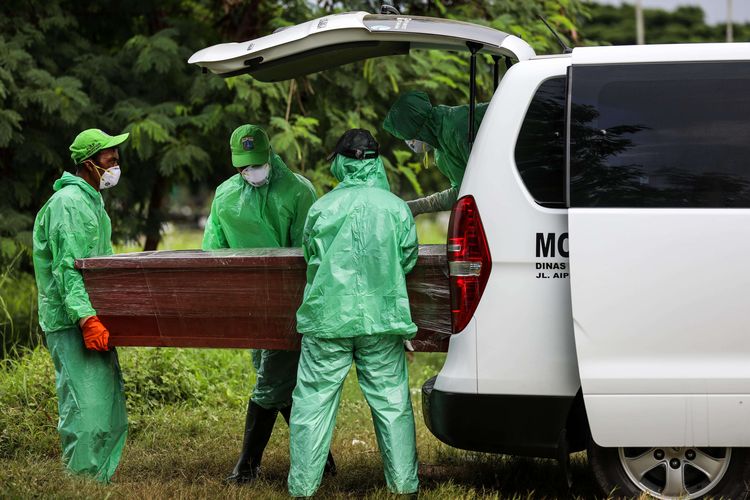 Petugas pemakaman mengeluarkan peti jenazah pasien suspect virus corona atau Covid-19 dari mobil ambulans di TPU Tegal Alur, Jakarta Barat, Kamis (26/3/2020). Pemprov DKI Jakarta telah menyiapkan dua tempat pemakaman umum (TPU) untuk memakamkan pasien terjangkit virus corona (Covid-19) yang meninggal dunia, yakni di TPU Tegal Alur di Jakarta Barat dan TPU Pondok Ranggon di Jakarta Timur. Jenazah yang dapat dimakamkan di sana, yakni yang berstatus pasien dalam pengawasan (PDP) dan berstatus positif terjangkit virus corona.