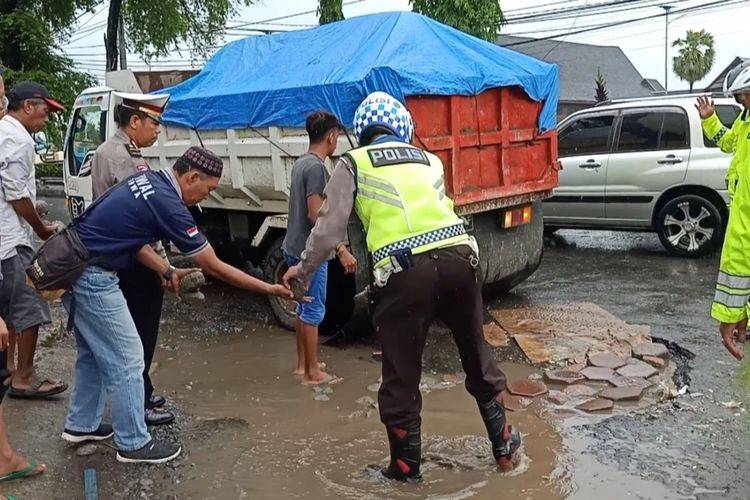Aparat kepolisian di Kabupaten Gowa, Sulawesi Selatan menutup jalan berlubang yang mengakibatkan seorang pengendara wanita tewas. Sabtu, (1/2/2020).