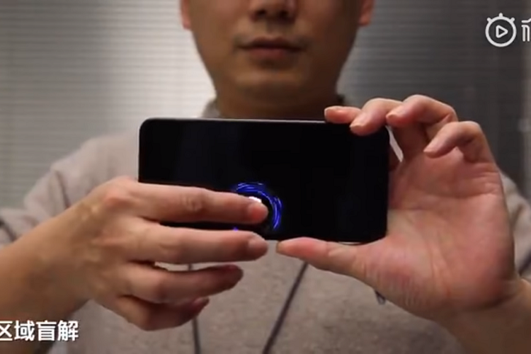Co-Founder dan President Xiaomi, Lin Bin memamerkan teknologi sensor pemindai sidik jari dalam layar Xiaomi yang diklaim bakal lebih canggih.