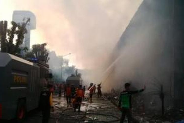 Petugas pemadam kebakaran dibantu aparat kepolisian berusaha memadamkan api yang melalap Kantor Gubernur Kalimantan Tengah, Minggu (1/11/2015).