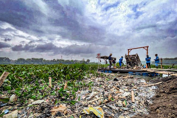 Aktivitas pengangkatan sampah plastik dari sungai Citarum menggunakan teknologi trash boom dan konveyor apung di Bandung Barat.