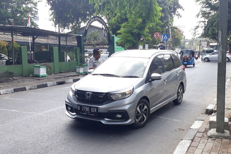 Petugas Dinas Perhubungan DKI Jakarta menginstruksikan pengendara mobil berputar balik karena melanggar ganjil genap di Jalan Pramuka, Jakarta Timur, Senin (9/9/2019).