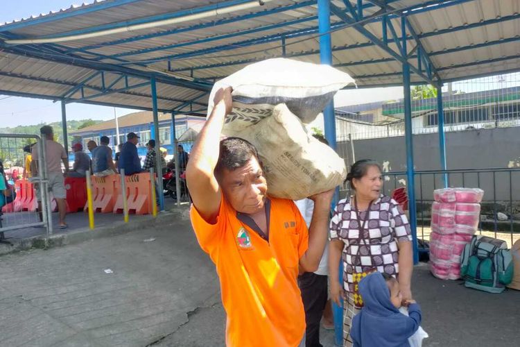 La Edi (52) buruh angkut di Pelabuhan Yos Sudarso Ambon saat memikul barang ke kapal, Selasa (14/3/2023)