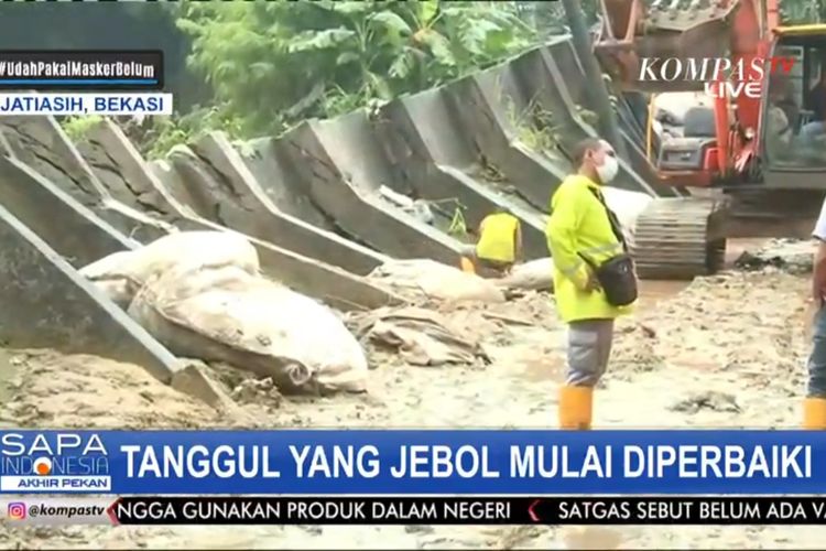 Proses perbaikan tanggul yang jebol setelah banjir di Perumahan Pondok Gede Permai, Bekasi mulai surut, Minggu (21/2/2021).