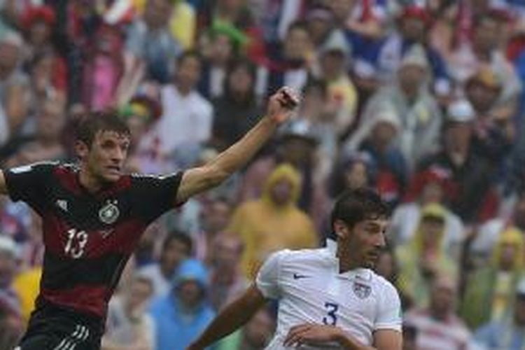 Penyeng Jerman, Thomas Mueller (kiri), berebut bola dengan bek AS, Omar Gonzalez, dalam laga penyisihan Grup G Piala Dunia 2014, Kamis (26/6/2014).