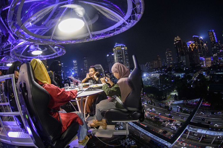 Pengunjung menyantap makanan dari ketinggian di Lounge in the Sky Indonesia di Jakarta, Selasa (29/3/2022). Destinasi wisata baru yang menawarkan sensasi menyantap hidangan dari ketinggian 50 meter dengan panorama Ibu Kota tersebut dapat dinikmati mulai dari harga Rp1,6 juta hingga Rp3,7 juta per orang.