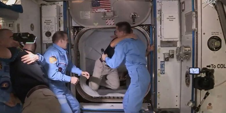 Astronot NASA yang menumpang kapsul Crew Dagon SpaceX, sampai di Stasiun Luar Angkasa Internasional (ISS) setelah 19 jam mengudara.  Astronot Douglas Hurley (kanan) dan Robert Behnken (kiri) tiba setelah pintu palka dibuka, keduanya disambut oleh astronot NASA dan kosmonot Rusia.