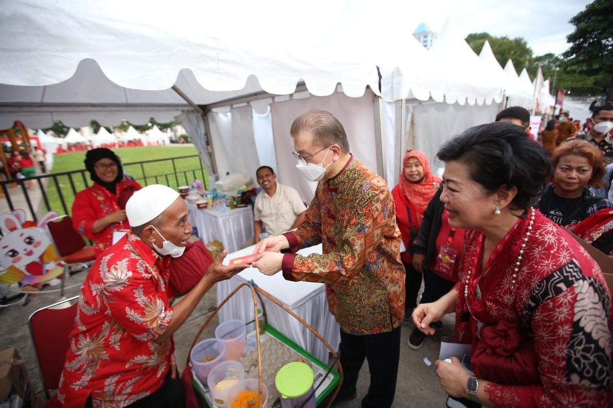 Ketua Panitia Imlek Nasional 2023 Franky Oesman Widjaja (tengah) bersama perwakilan Yayasan Buddha Tzu Chi memberikan angpao kepada UMKM saat acara Imlek Nasional 2023.

