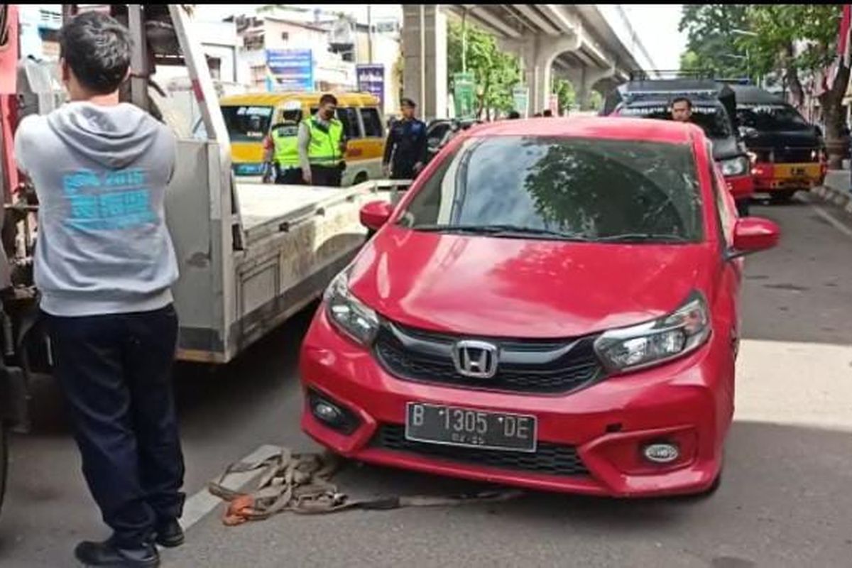Mobil Honda Biro yang teparkir di pinggir jalan Jenderal Sudirman diderek oleh petugas lantaran ditemukan satu unit senjata laras panjang, Jumat 24/6/2022). Setelah dilakukan pemeriksaan, senjata tersebut merupakan mainan.