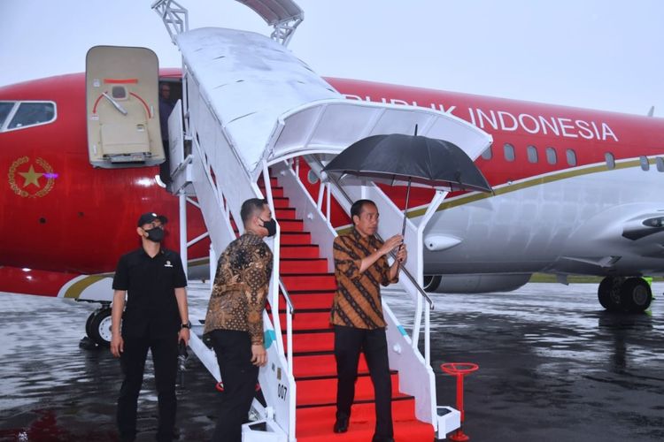 Presiden Joko Widodo memegang payung sendiri saat baru mendarat di Bandara Internasional Syamsudin Noor, Kota Banjarbaru, Provinsi Kalimantan Selatan (Kalsel), pada Kamis (16/3/2023).