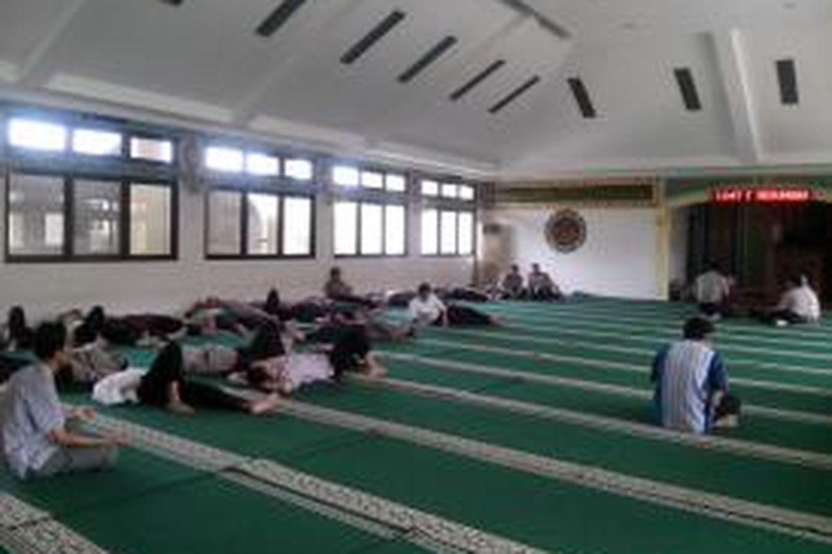 Usai melaksanakan salat zuhur, para pegawai tidur-tiduran di dalam masjid.