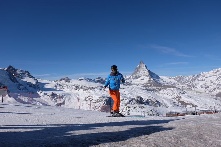 Pemain ski dengan latar puncak Gunung Matterhorn. 
