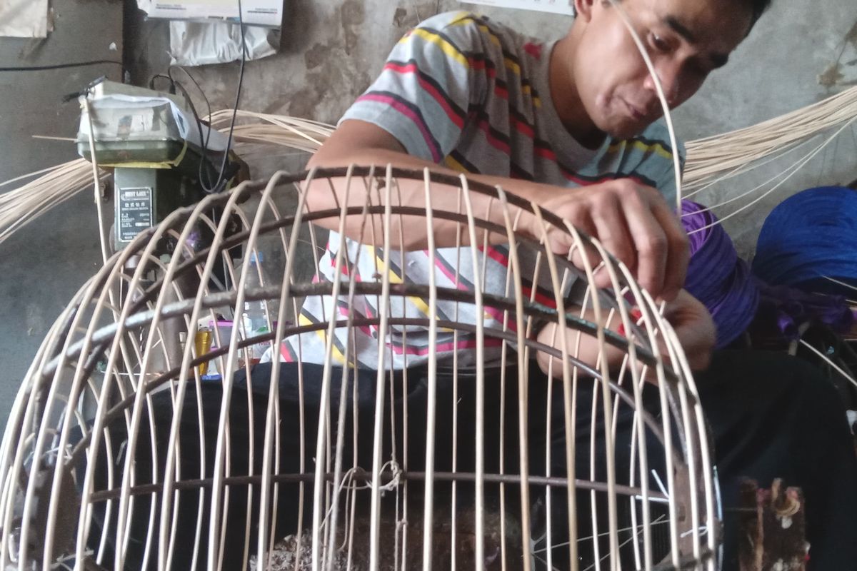 Perajin lampion tengah membuat lampion berbentuk bulat di garasi rumah yang dijadikan tempat produksi lampion, di Kota Bandung, Sabtu (18/1/2025).