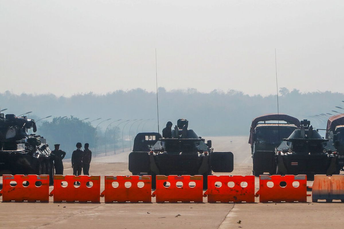 Militer Myanmar berjaga di sebuah pos pemeriksaan dengan kendaraan lapis baja yang memblokir jalan menuju gedung parlemen pada Selasa, (2/2/2021).