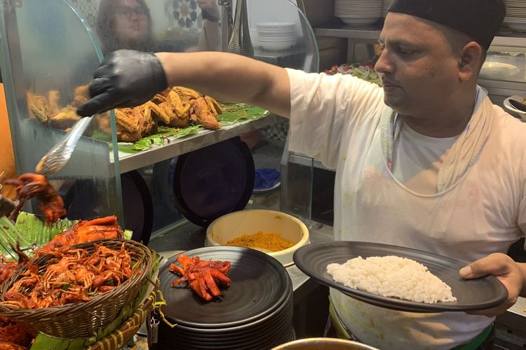Pelanggan harus mengantre bila banyak yang memesan nasi kandar. Begitu tiba di depan etalase, pelanggan bisa memilih lauk yang diingkan untuk santapan siang maupun malam hari di Restoran Hameediyah, tempat makan nasi kandar pertama di Penang, Malaysia.