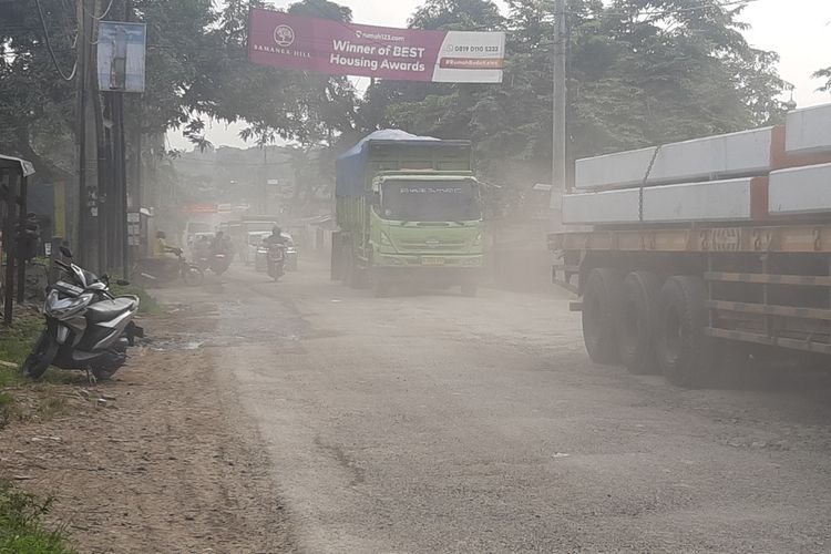 Kondisi jalan rusak dan berdebu akibat truk tambang yang melintas di Jalan Parung Panjang, Kabupaten Bogor, Jawa Barat, Rabu (8/1/2025) siang.