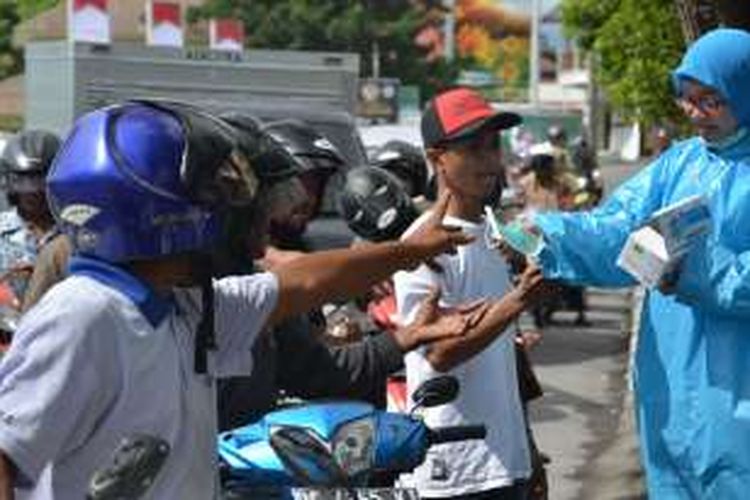 Petugas dari Dinas Kesehatan Kota Ternate saat membagikan masker gratis kepada warga di jalan-jalan, Rabu (3/8/2016)