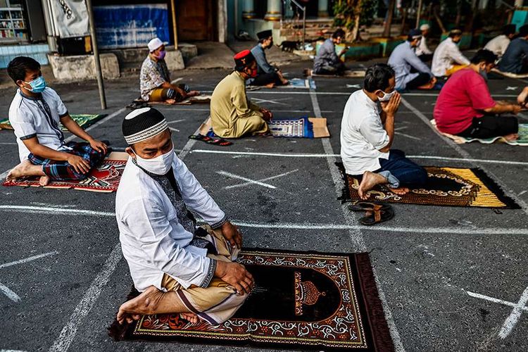 Umat muslim melaksanakan shalat Idul Adha di Jalan Pramuka Raya, Cempaka Putih, Jakarta Timur, Jumat (31/7/2020). Umat muslim menggelar shalat Idul Adha secara berjamaah dengan menerapkan protokol kesehatan seperti jaga jarak serta wajib mengenakan masker guna mencegah penyebaran COVID-19.