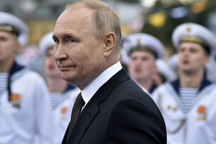 Presiden Rusia Vladimir Putin saat meninjau pasukan Angkatan Laut di parade untuk merayakan Russian Navy Day di St Petersburg, Minggu (31/7/2022). Baru-baru ini tersiar informasi bahwa Ukraina tengah merancang rencana untuk mengadili dan menangkap Putin.