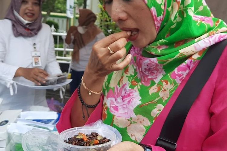 Penikmat ungker goreng, Ernita saat mencicipi makanan ekstrem ungker goreng pada 'Festival Kuliner 2022' di Alun-alun Blora, Jawa Tengah, Rabu (7/12/2022).