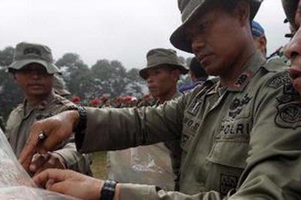 Anggota Brimob mempelajari peta lokasi jatuhnya pesawat Sukhoi Superjet 100 di Gunung Salak sebalum berangkat melakukan pencarian korban usai apel gabungan di Dodiklatpur Rindam Jaya, Bogor, Jawa Barat, Kamis (10/5/2012). Pesawat Sukhoi SJ 100 jatuh di Gunung Salak Selasa (8/5/2012) dengan membawa penumpang 50 orang. 